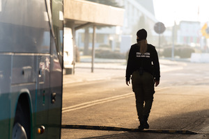 przejście graniczne w Korczowej. Funkcjonariuszka Straży Granicznej stoi przy autobusie przejście graniczne w Korczowej. Funkcjonariuszka Straży Granicznej stoi przy autobusie